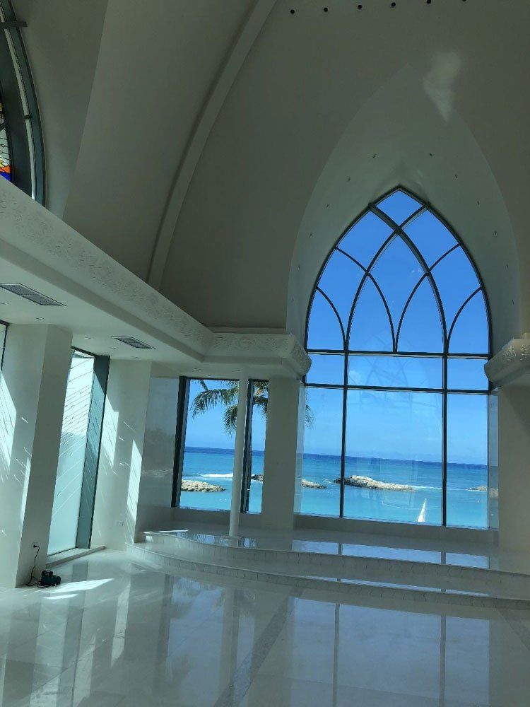 An empty room with a large window overlooking the ocean