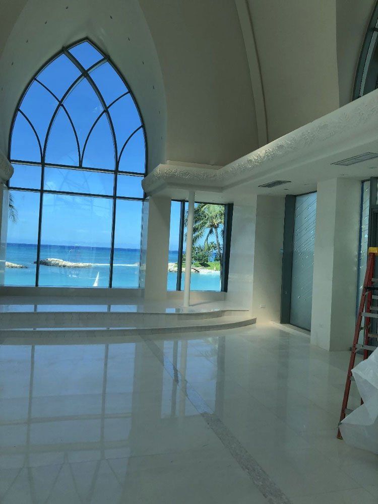 An empty room with a large window looking out to the ocean