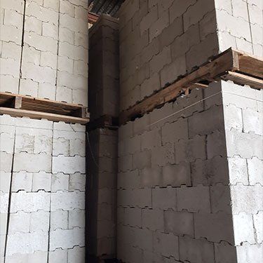 A warehouse filled with lots of bricks and wooden pallets