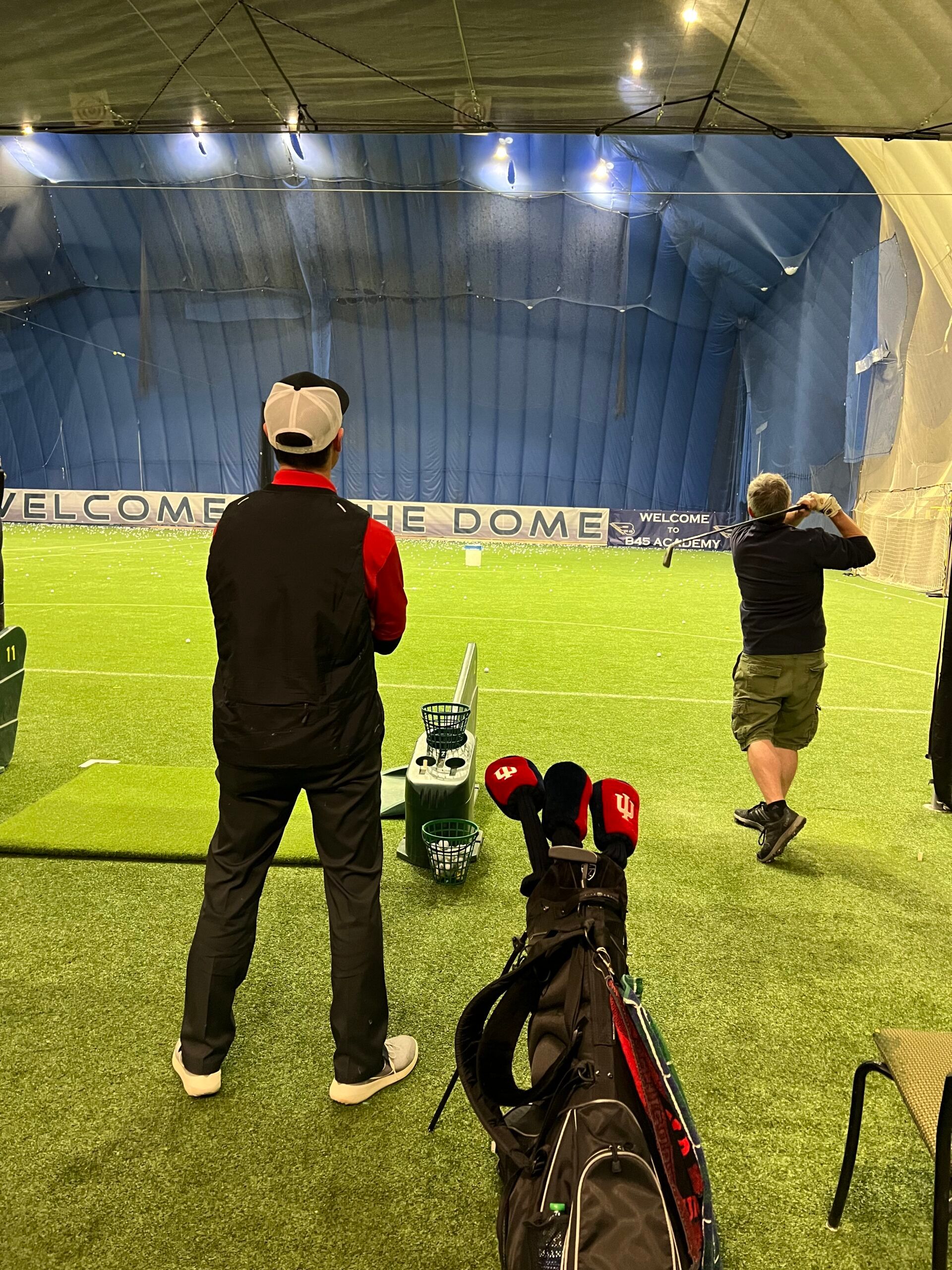 A man is standing on a golf course looking at a golf ball.