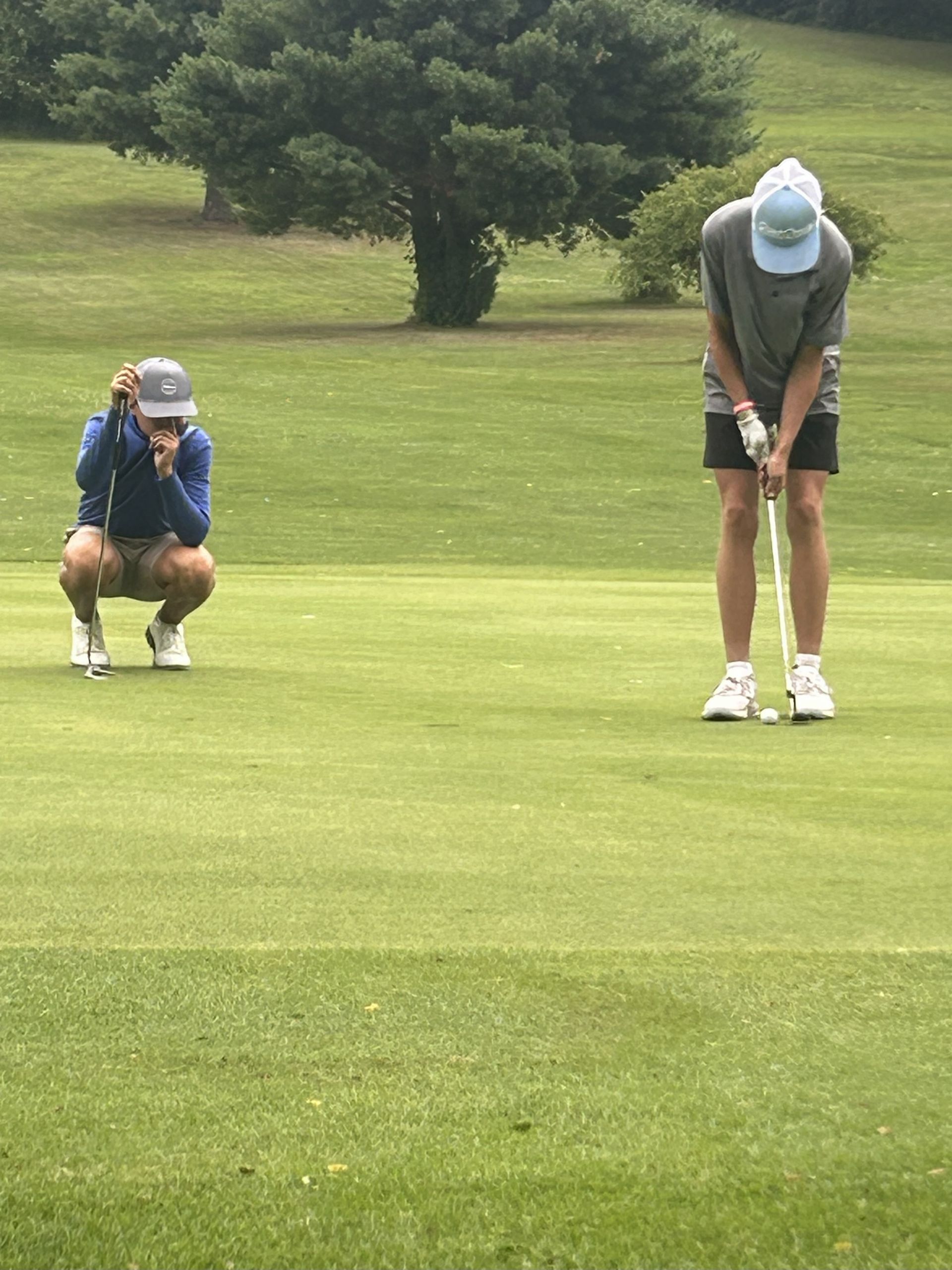 Golf balls scattered on artificial green grass inside a dome-shaped indoor driving range.
