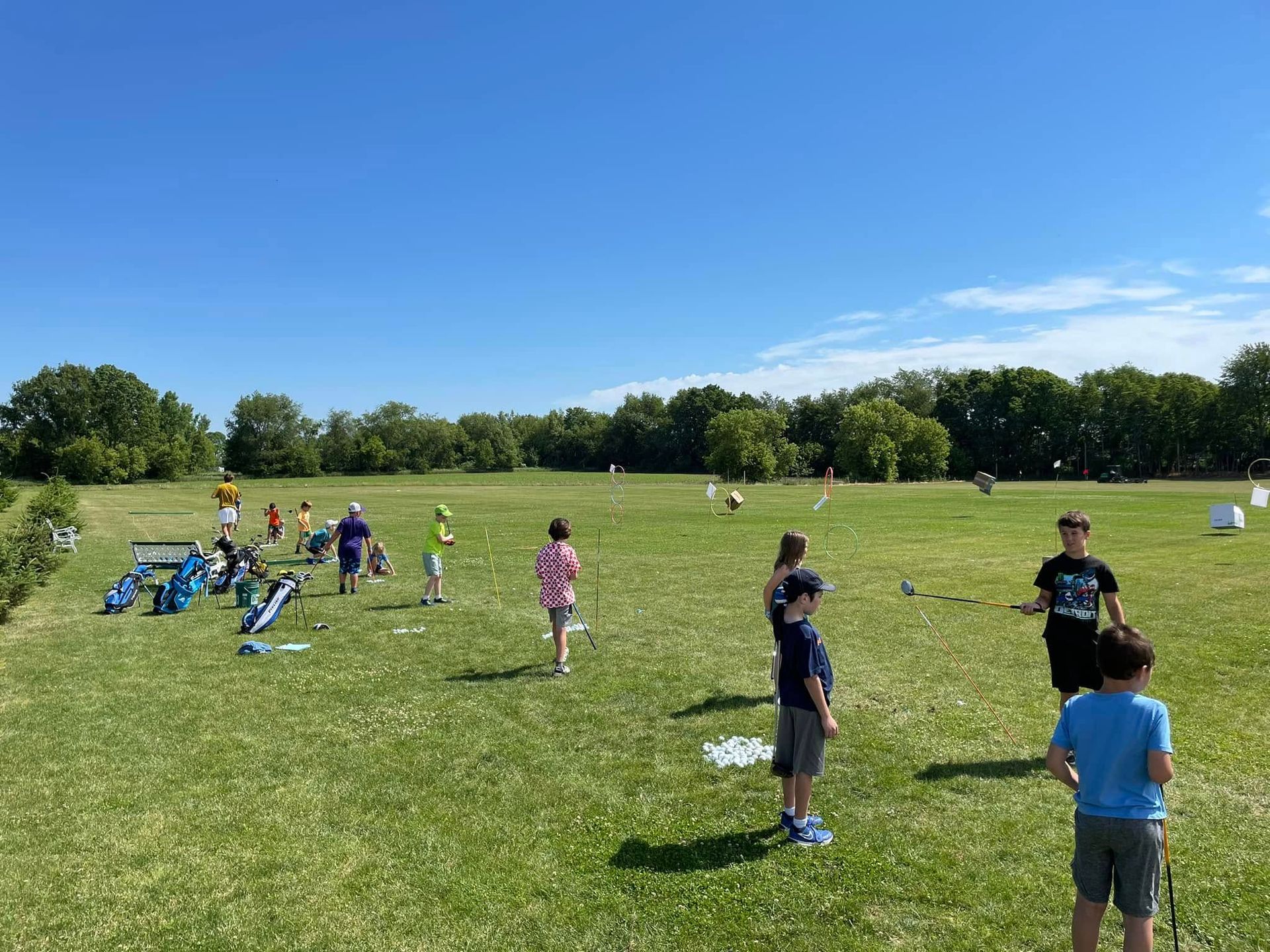Golf balls scattered on artificial green grass inside a dome-shaped indoor driving range.