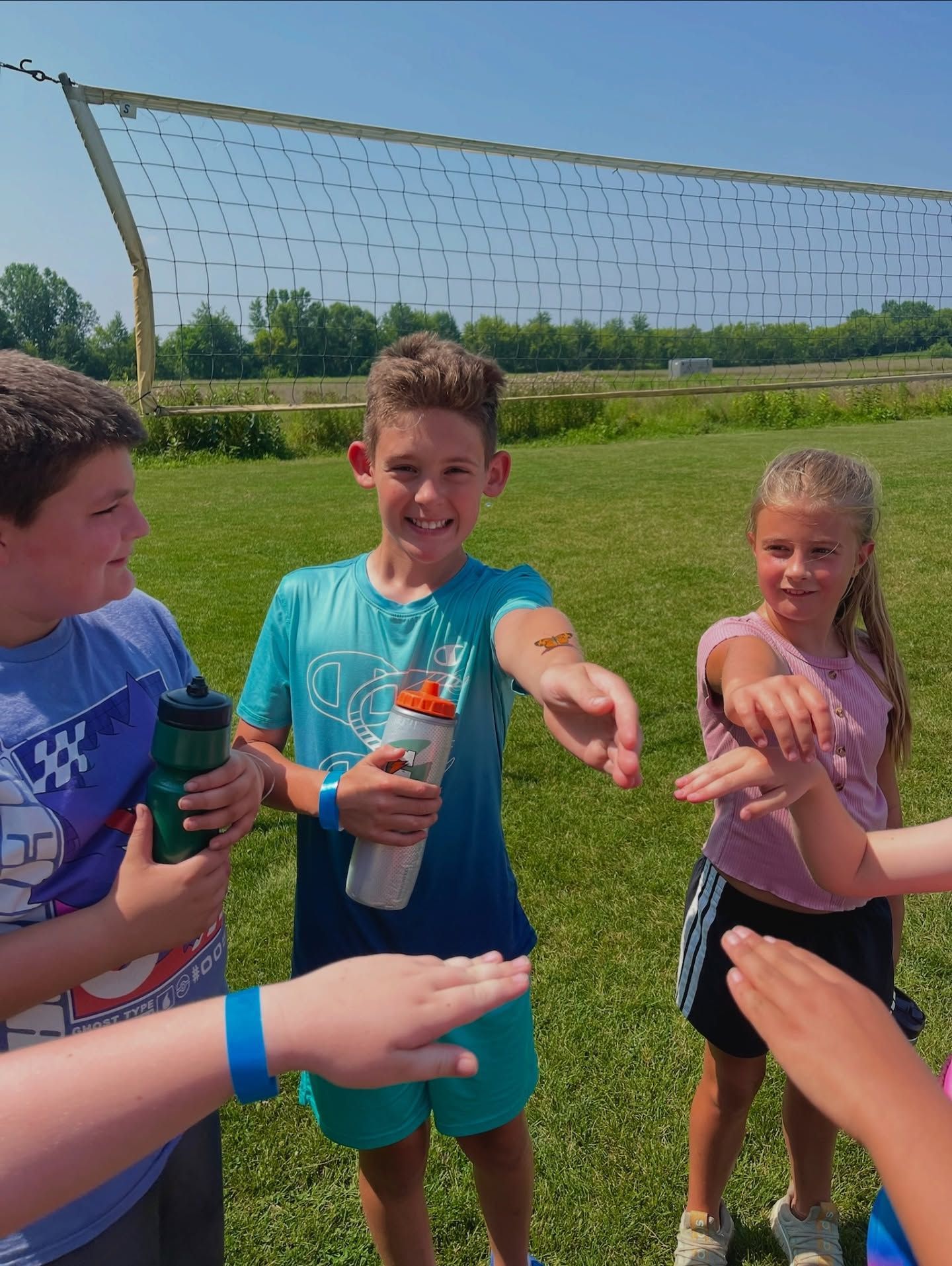Aerial view of a white dome-shaped building with a parking lot, surrounded by green fields and trees.