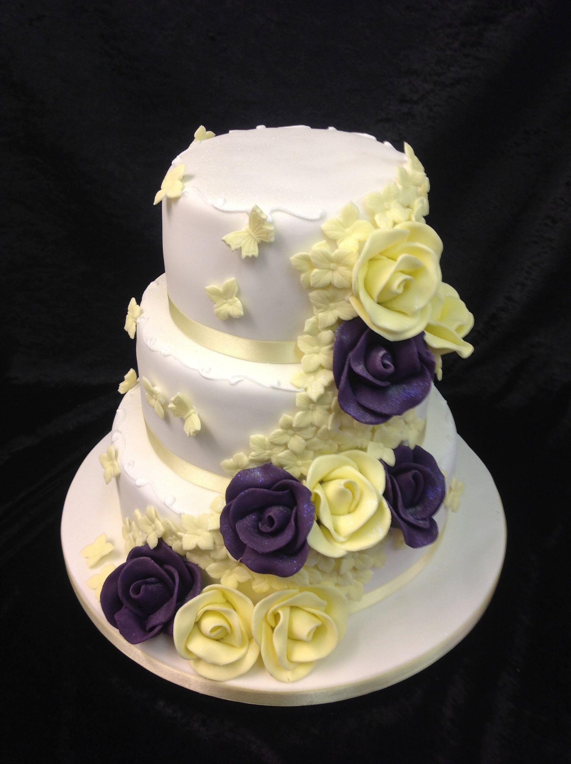 3 tier cake with yellow and purple roses