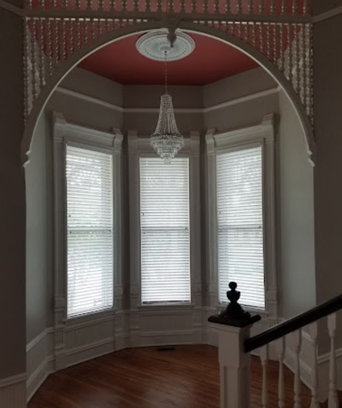 An empty room with a chandelier hanging from the ceiling