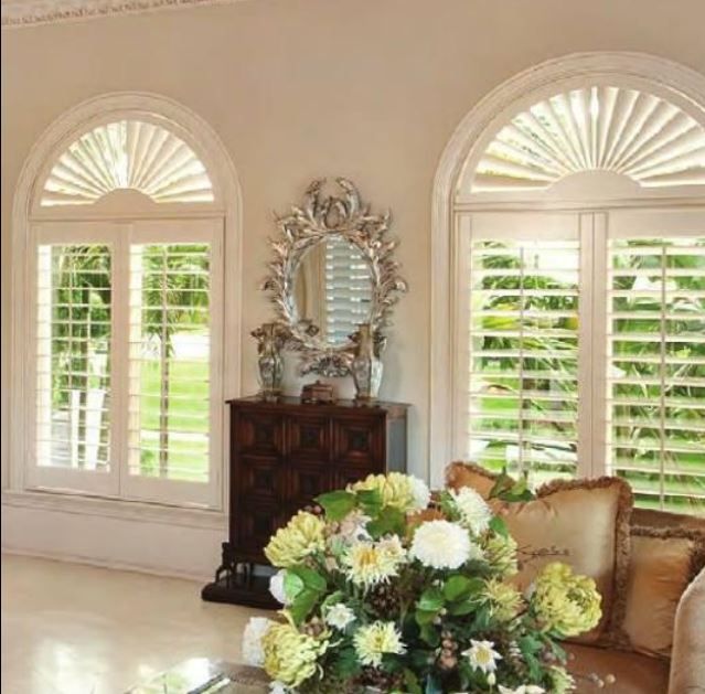 A living room with a couch and a vase of flowers