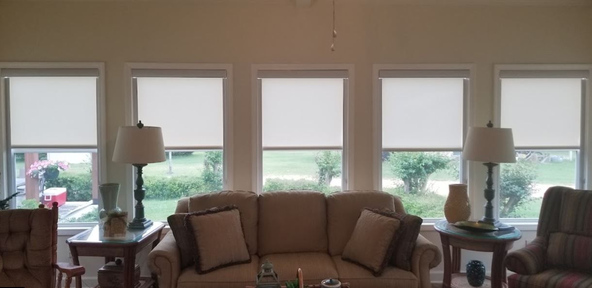 A living room with a couch , chairs and lamps