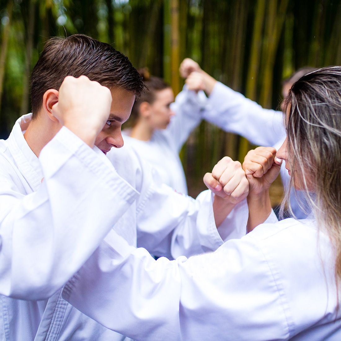 A group of people are practicing martial arts in a forest.