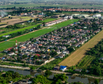 An aerial view of a residential area surrounded by fields and trees.