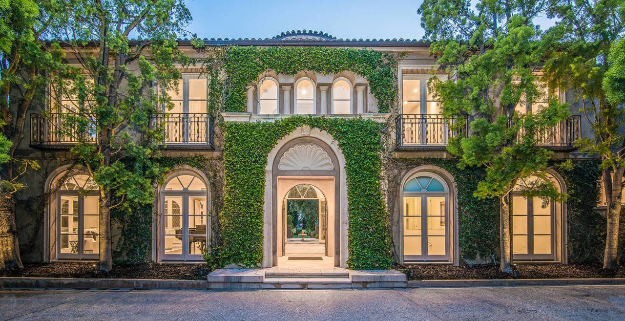 A large house with a lot of windows and trees in front of it.