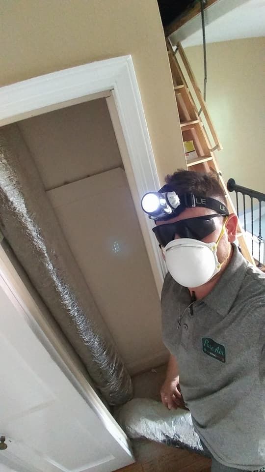 A man wearing a mask and a headlight is standing in a doorway.