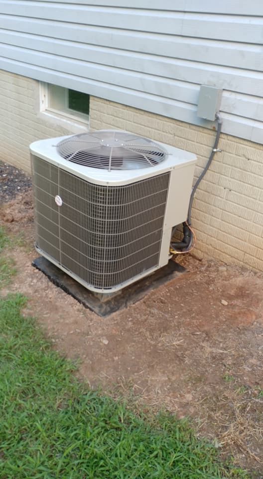 A large air conditioner is sitting on the side of a house.