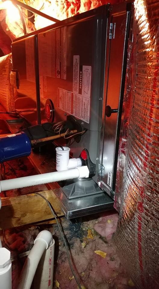 A furnace is sitting in the attic of a house.