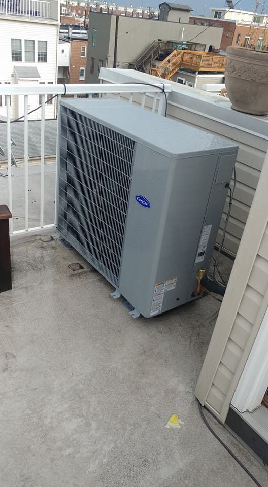 A large air conditioner is sitting on the roof of a building.