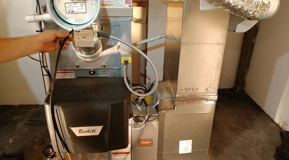 A person is looking at a furnace with a magnifying glass.