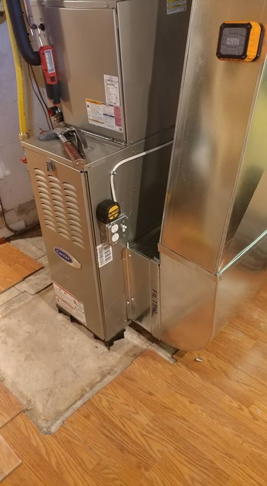 An air conditioner is sitting on top of a wooden floor in a room.