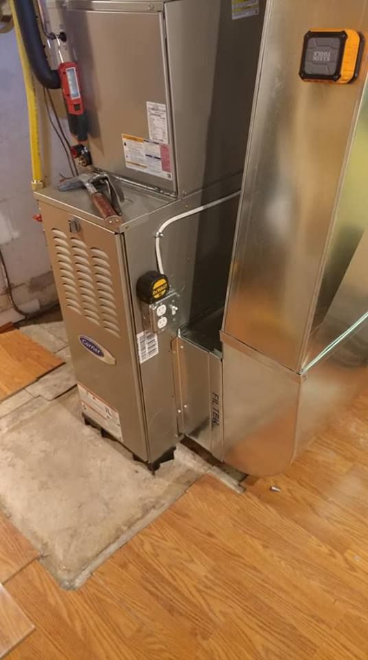 A stainless steel air conditioner is sitting on top of a wooden floor in a room.