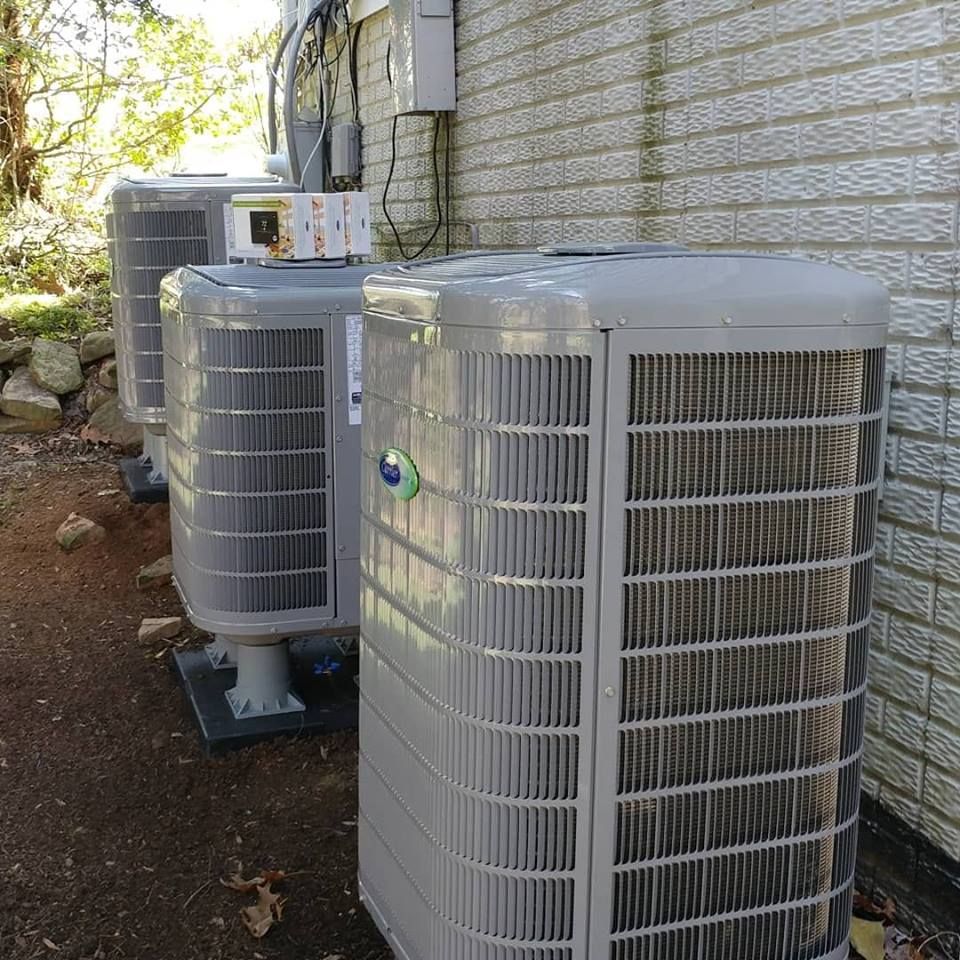 A row of air conditioners on the side of a building