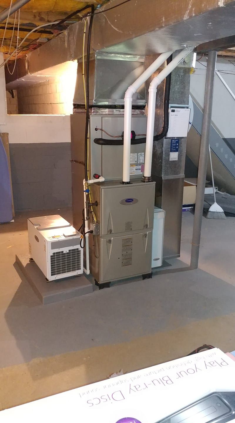 A basement with a furnace and air conditioner in it.