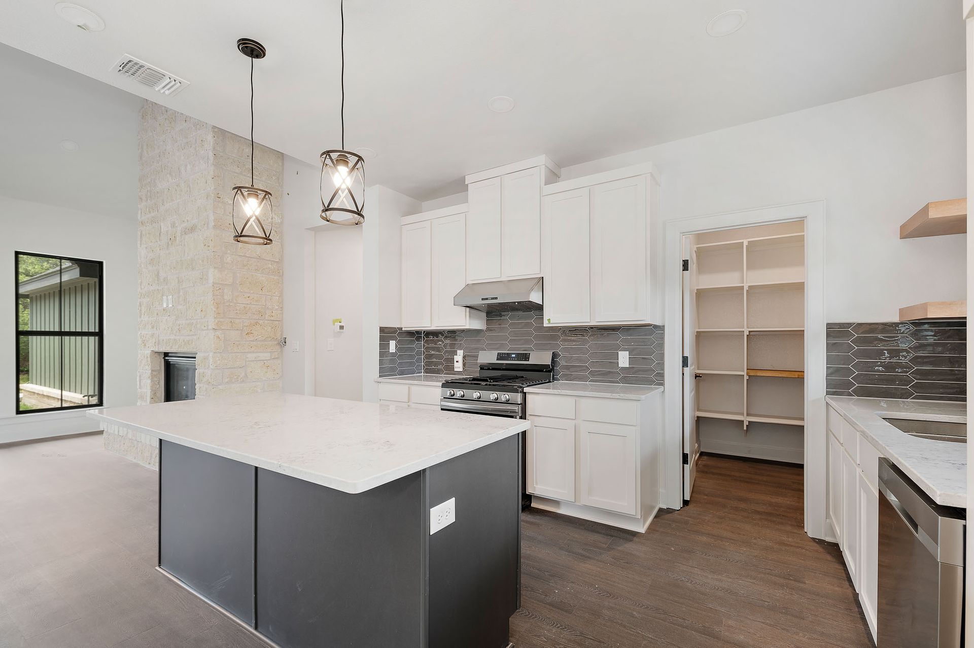 A kitchen with white cabinets , stainless steel appliances , and a large island.