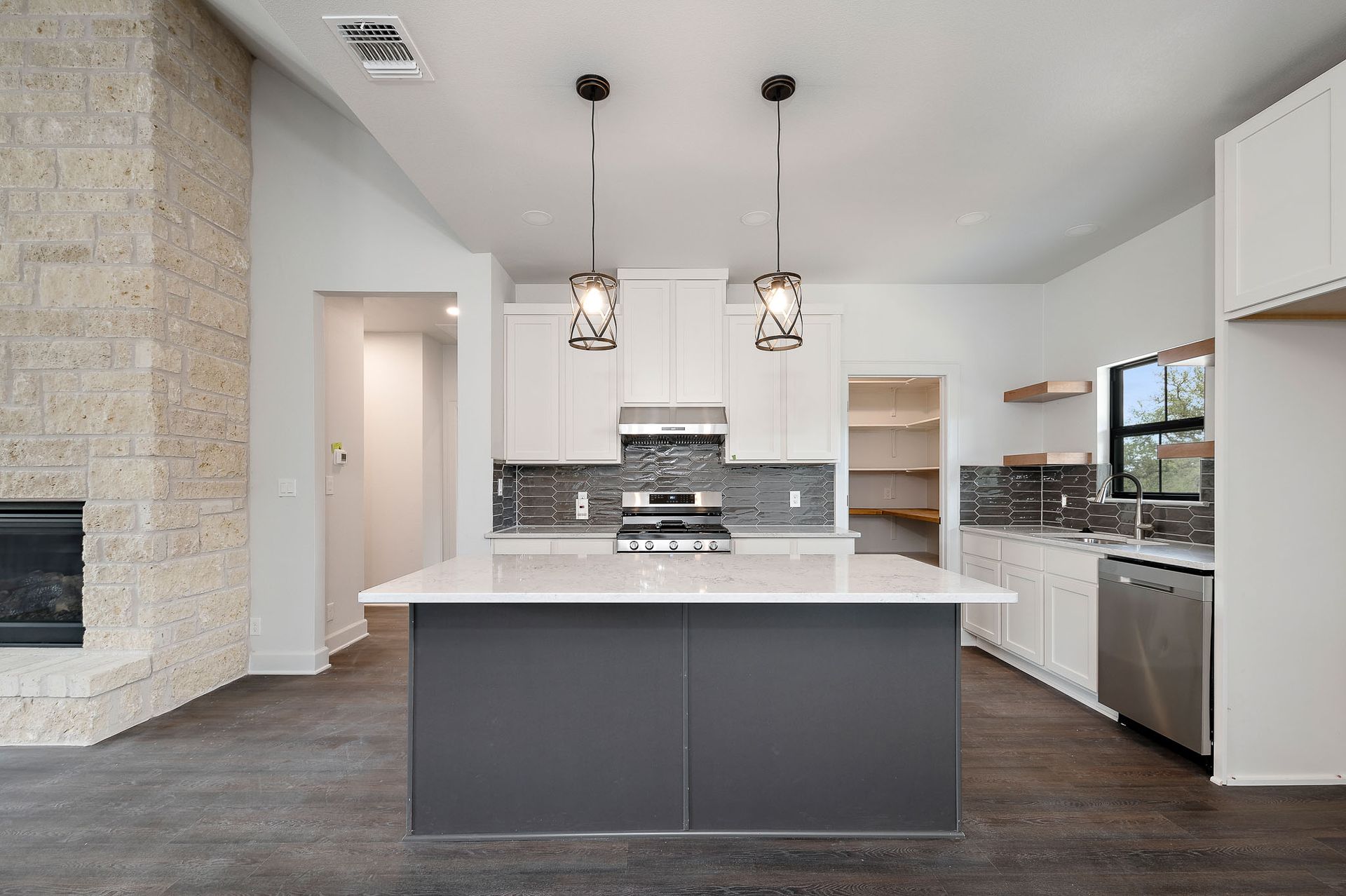 An empty kitchen with a large island in the middle