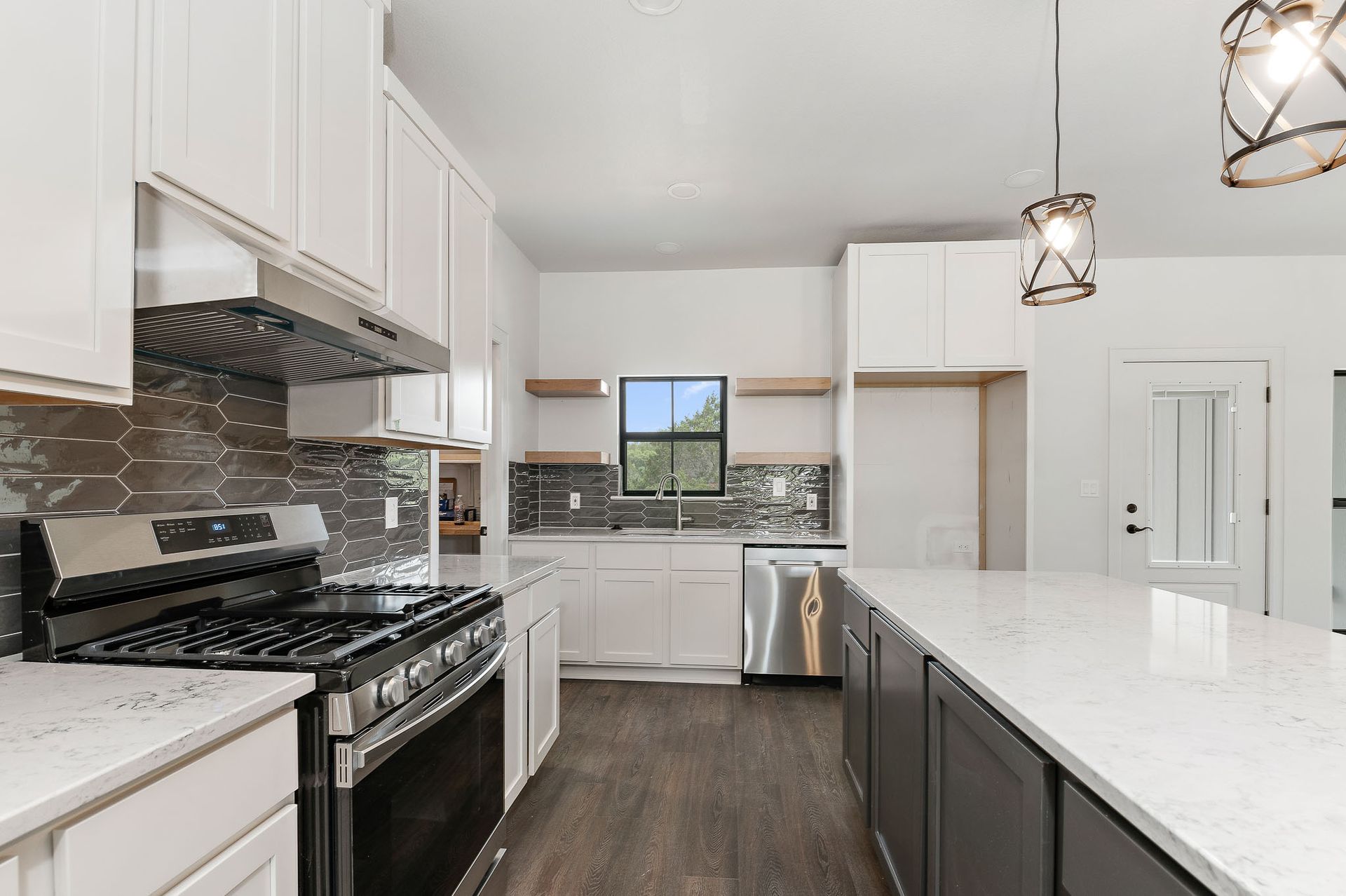 A kitchen with white cabinets , stainless steel appliances , and a large island.