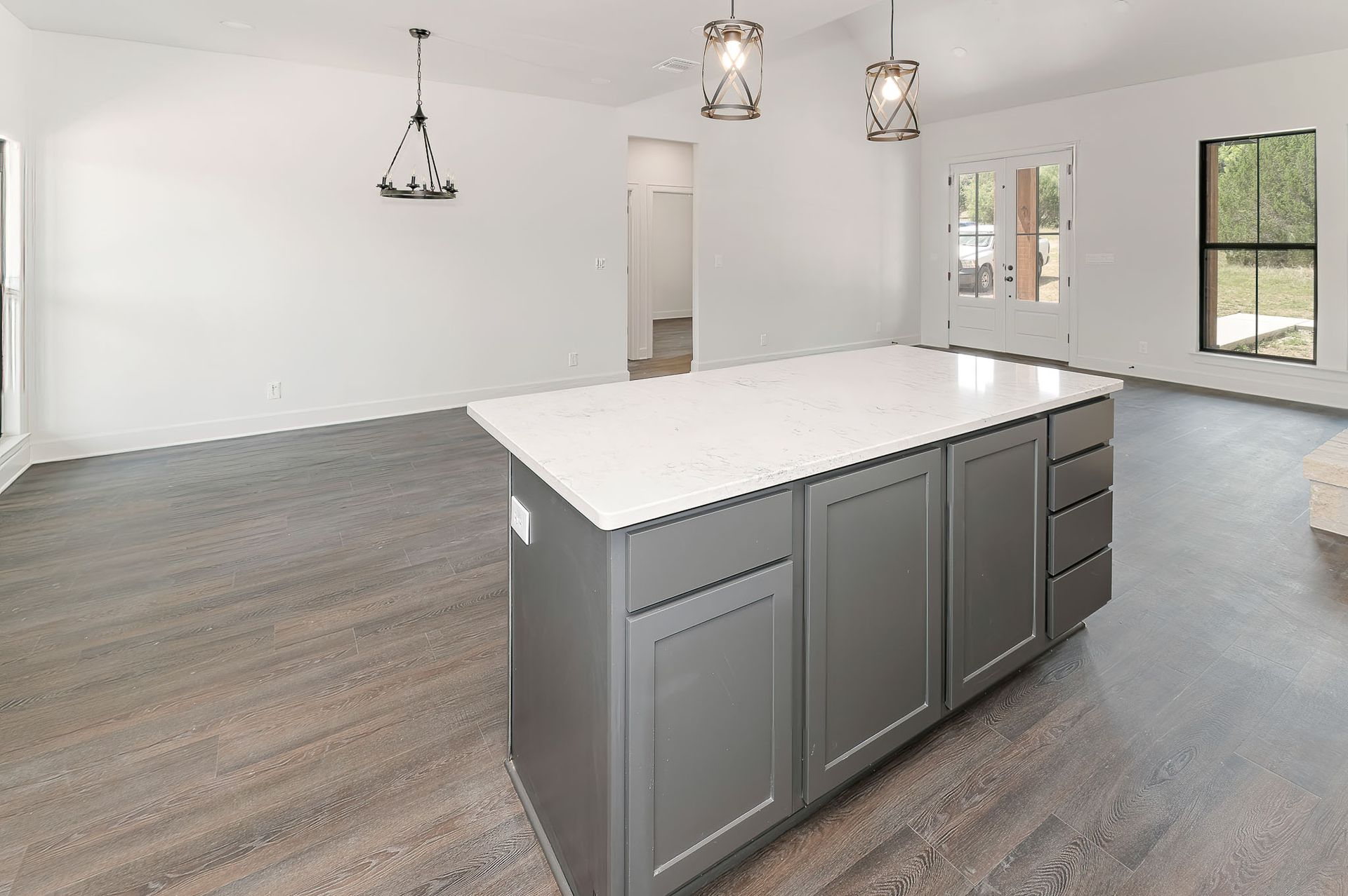 An empty kitchen with a large island in the middle of the room.