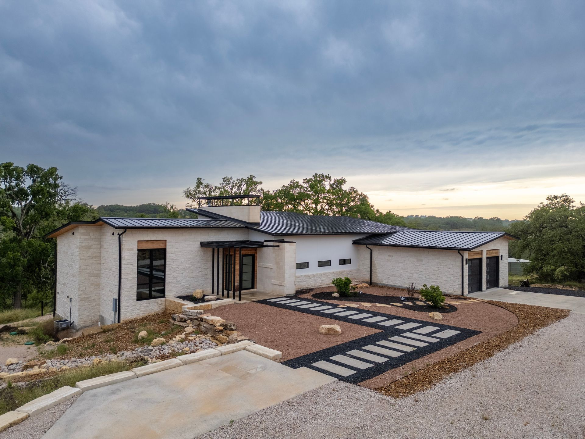 A large white house with a large driveway in front of it.
