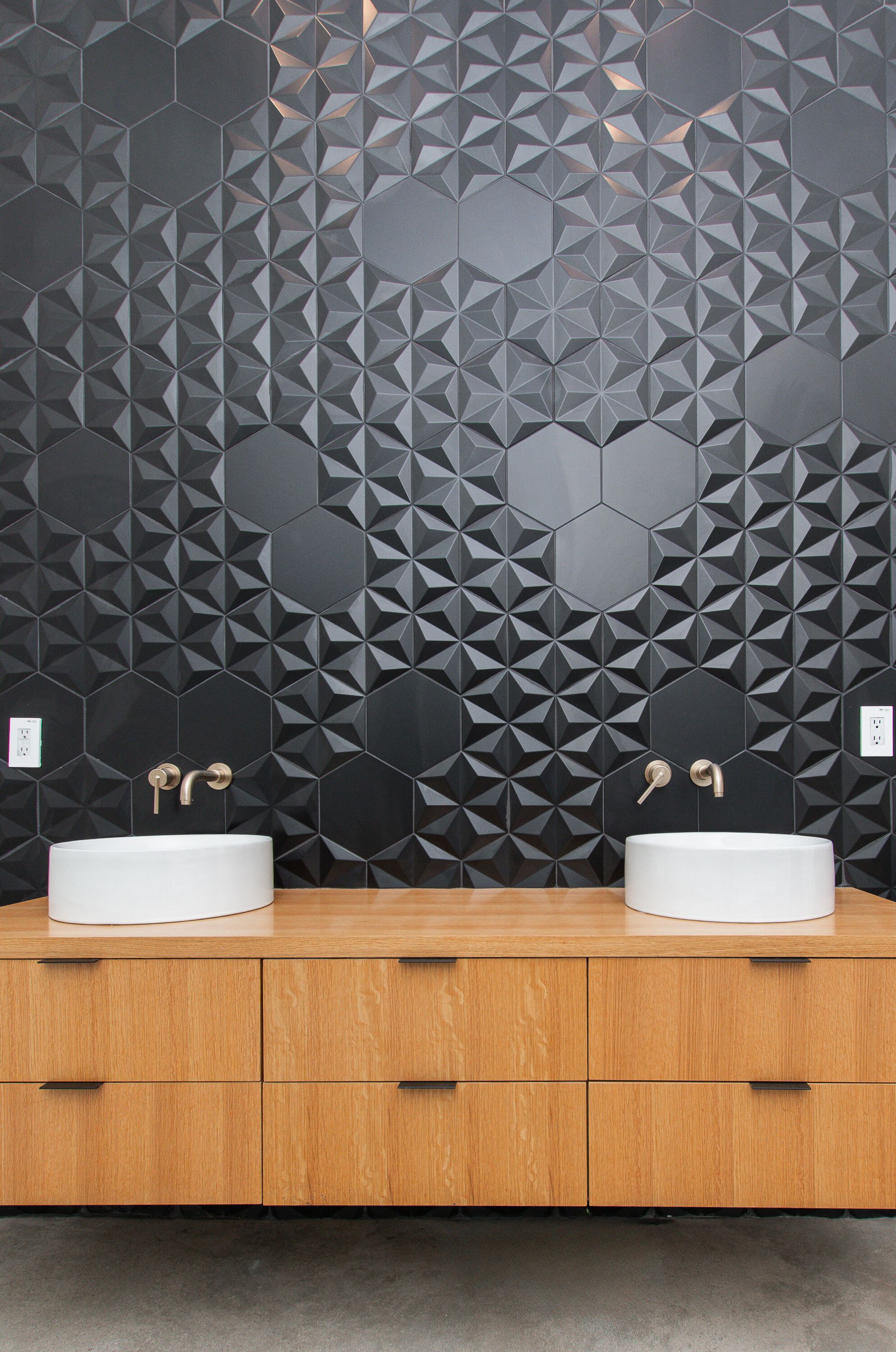 A bathroom with two sinks and a black wall.