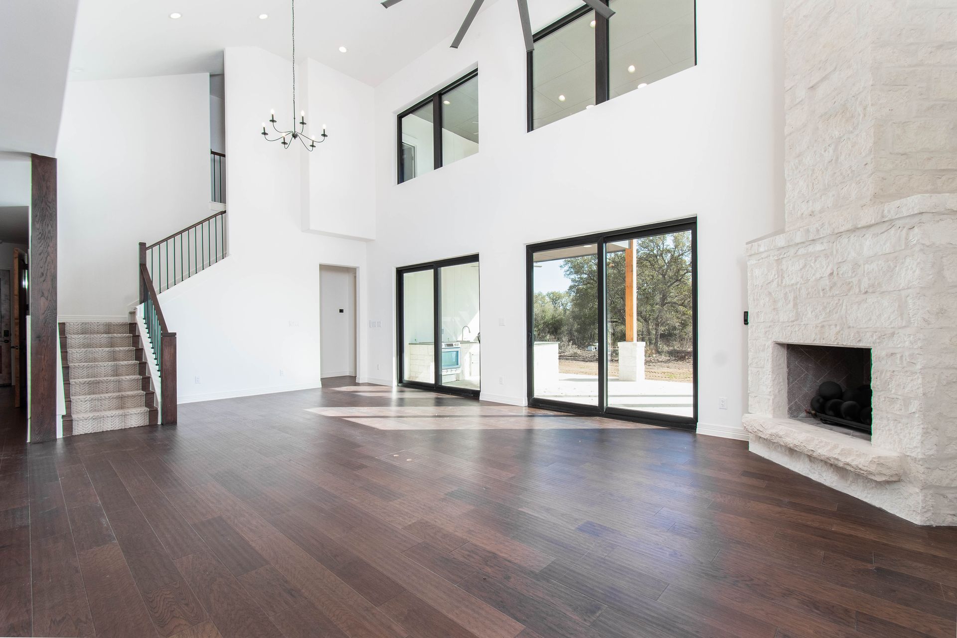 A large empty living room with hardwood floors and a fireplace.