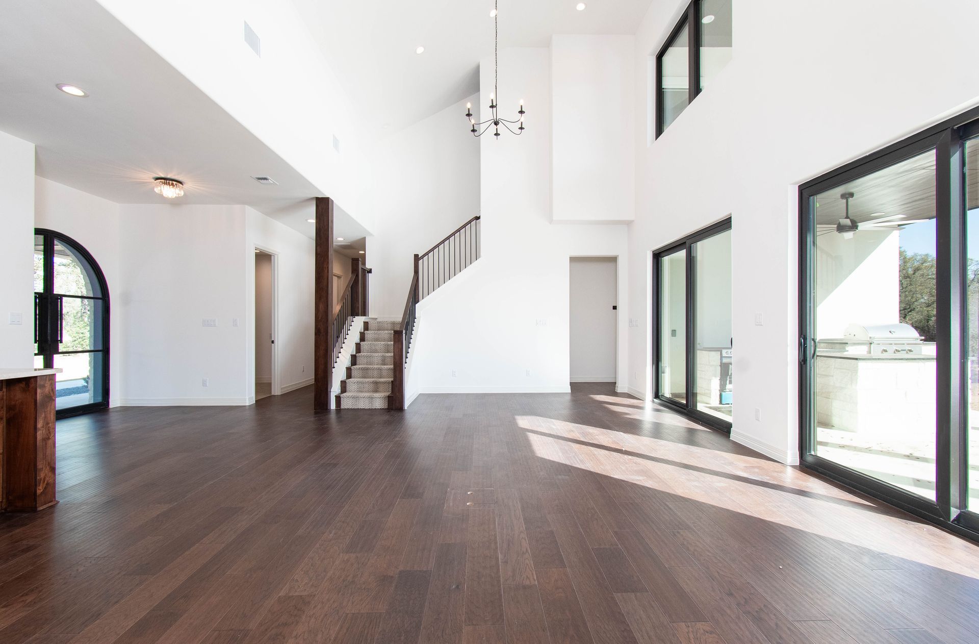 A large empty room with a staircase and lots of windows