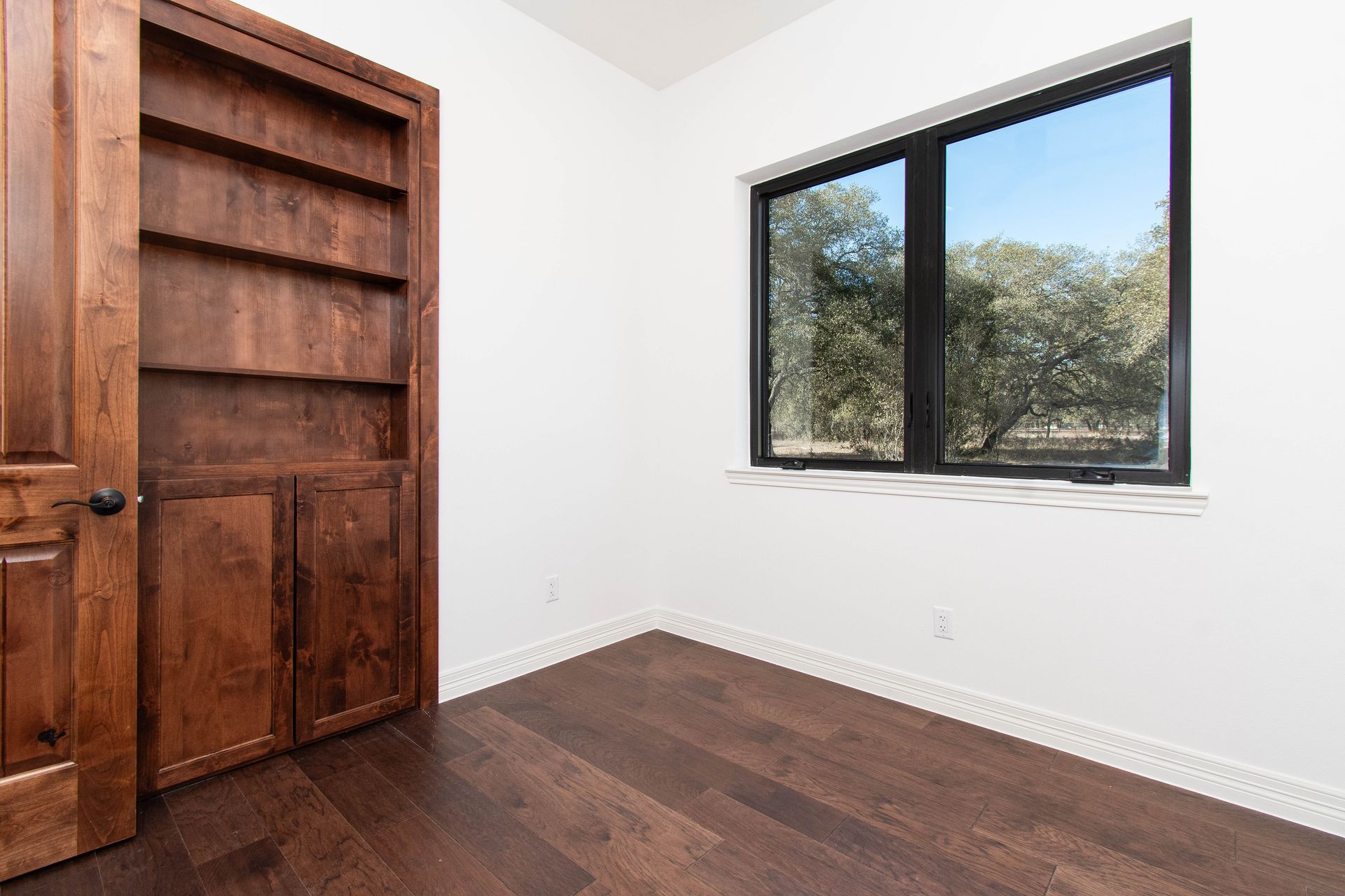 An empty room with a bookshelf and a window.