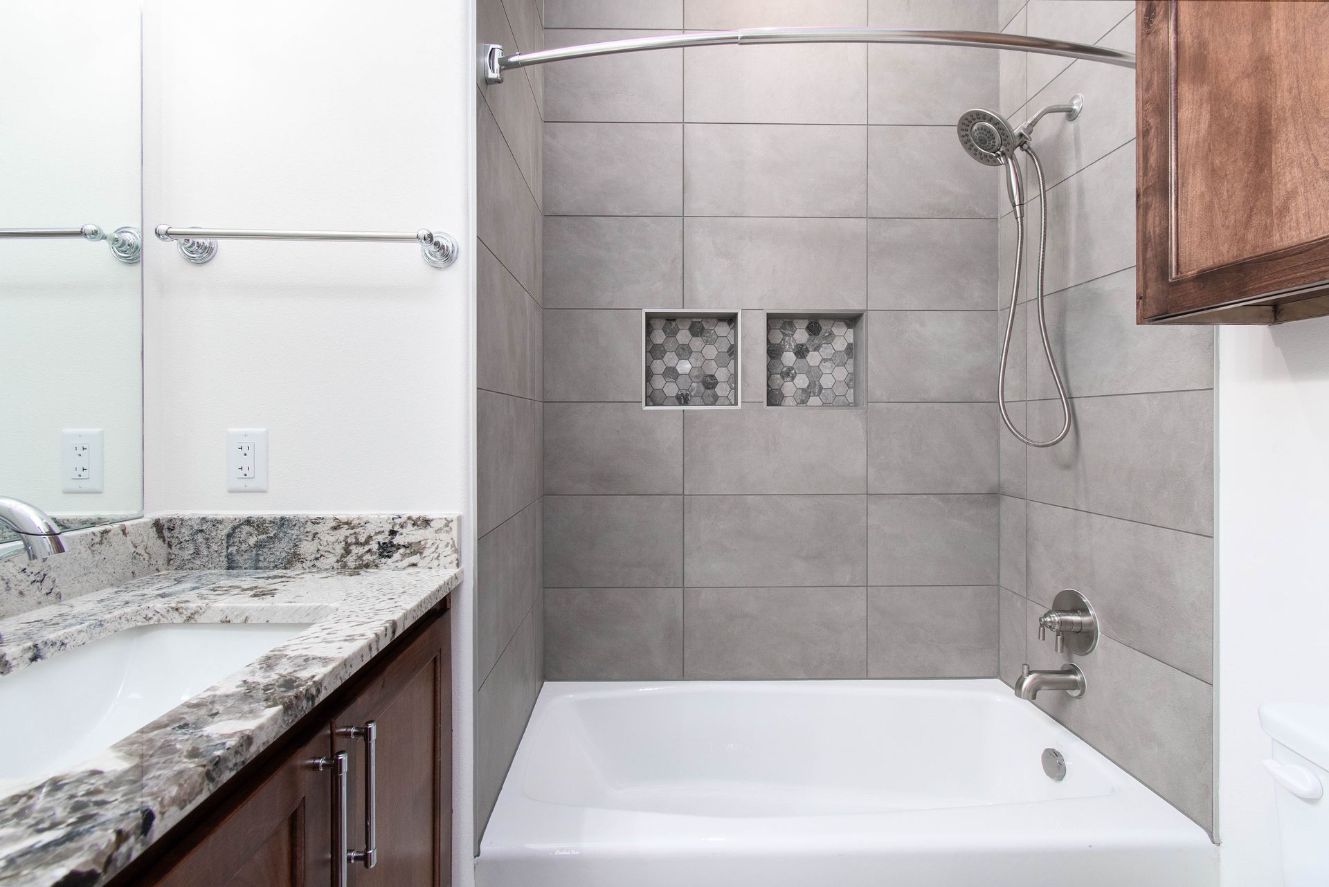 A bathroom with a bathtub , sink and shower.