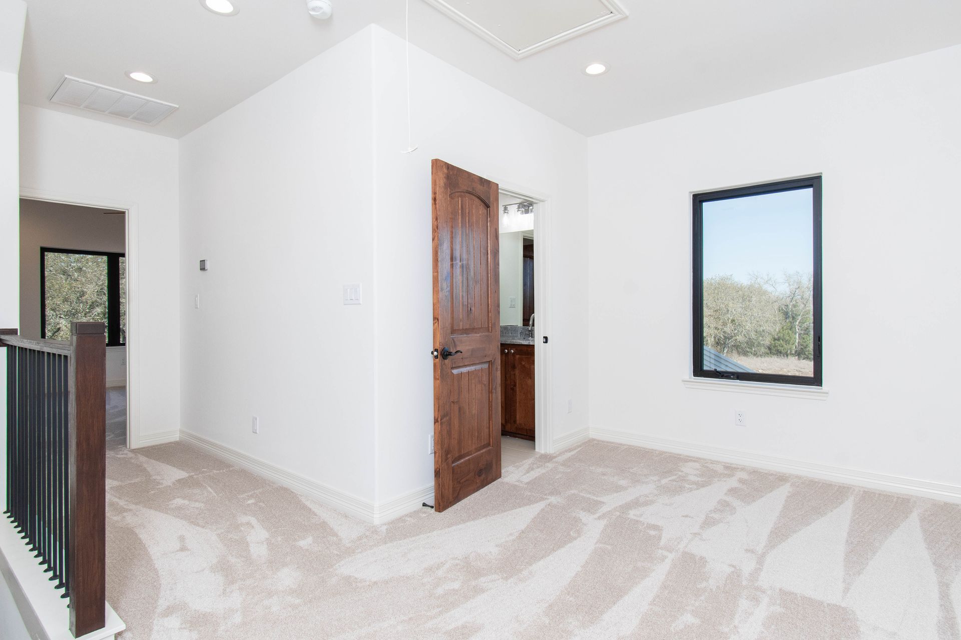 An empty room with a wooden door and a window.
