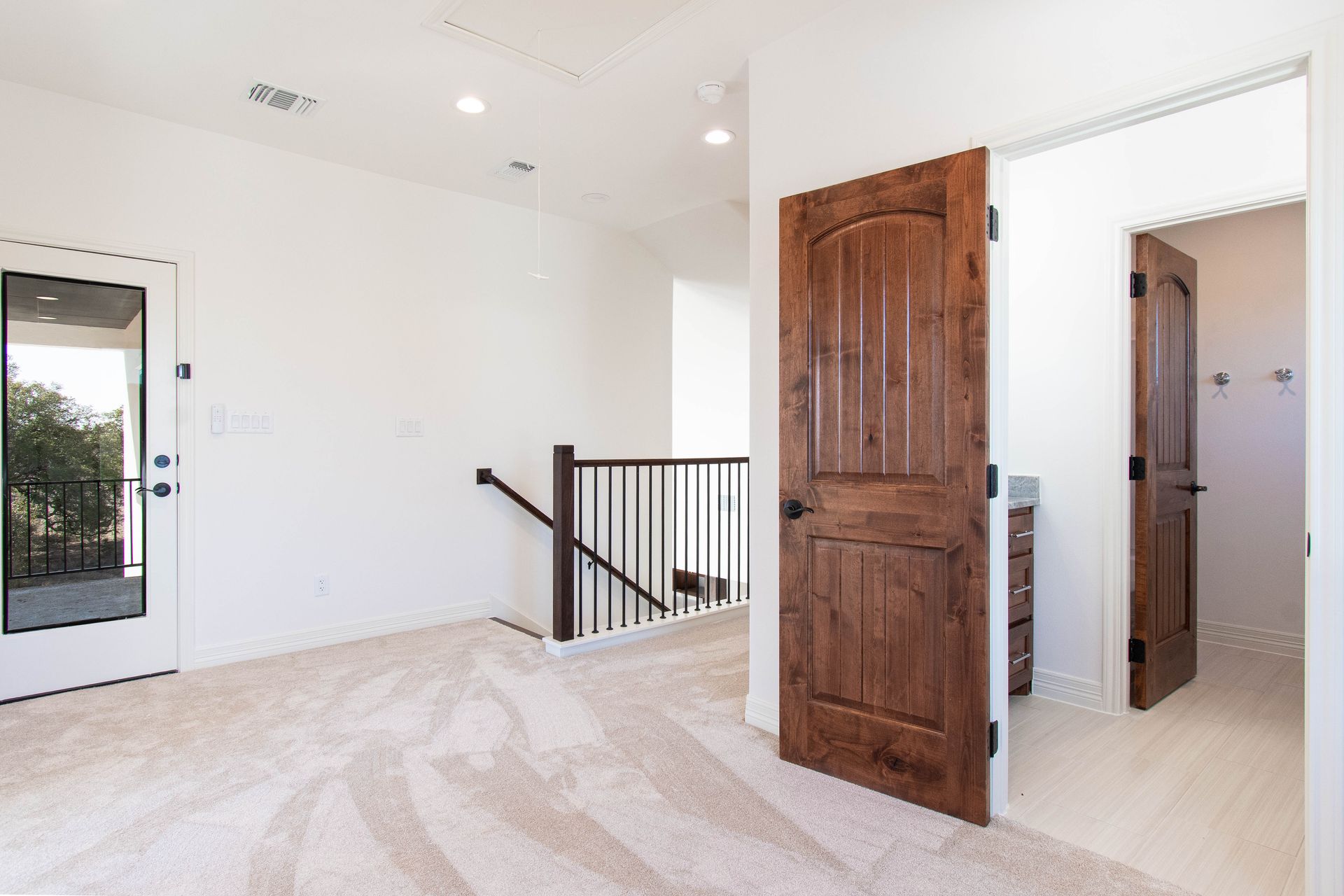 An empty room with a wooden door and stairs in a house.