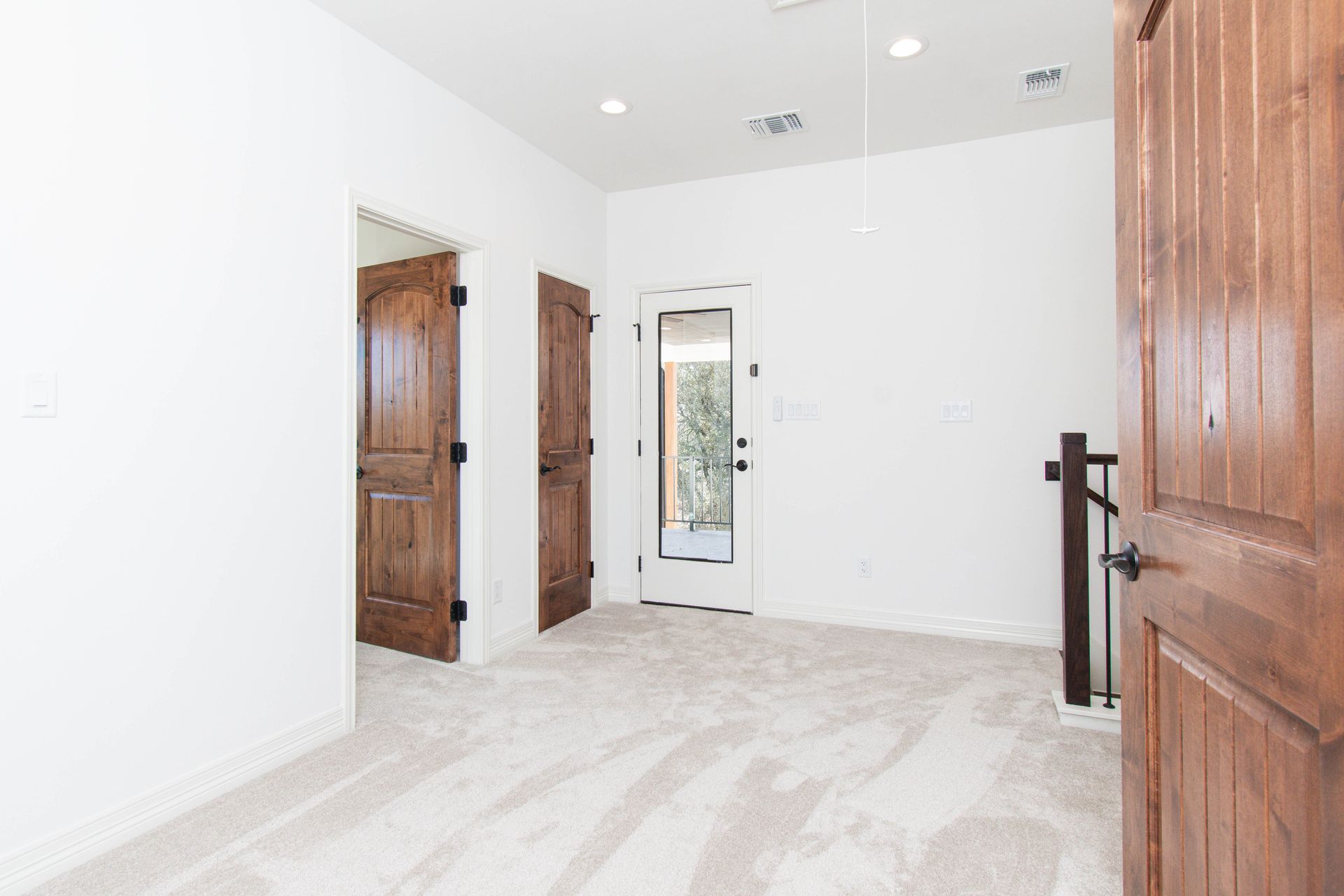 An empty room with a wooden door and two wooden doors.