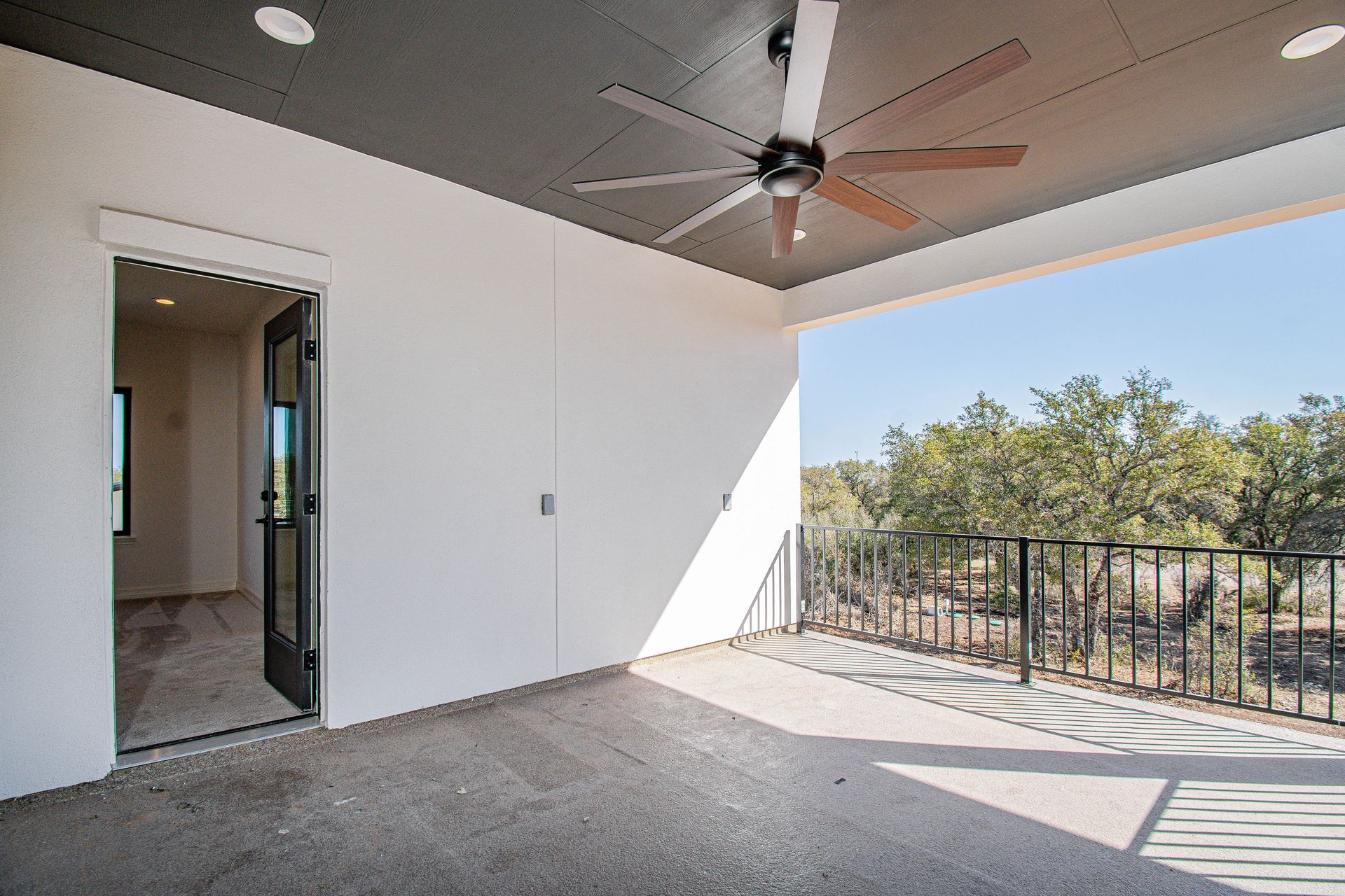 There is a ceiling fan on the porch of a house.