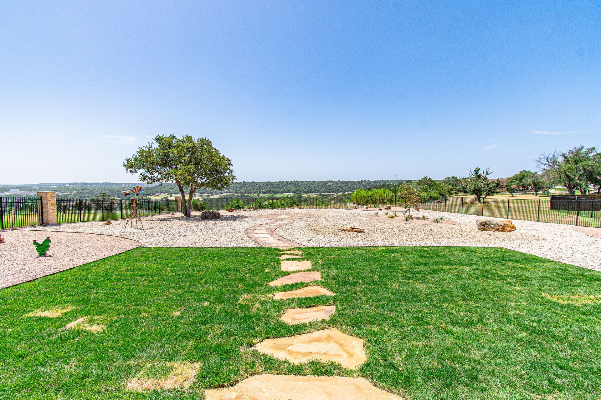 A stone path leading through a lush green field.