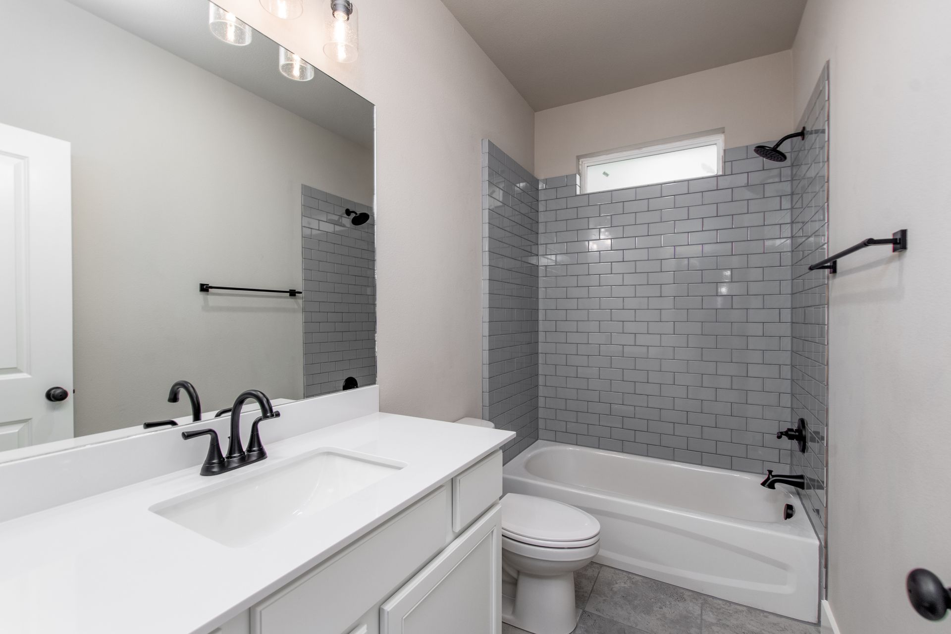 A bathroom with a sink , toilet , bathtub and mirror.