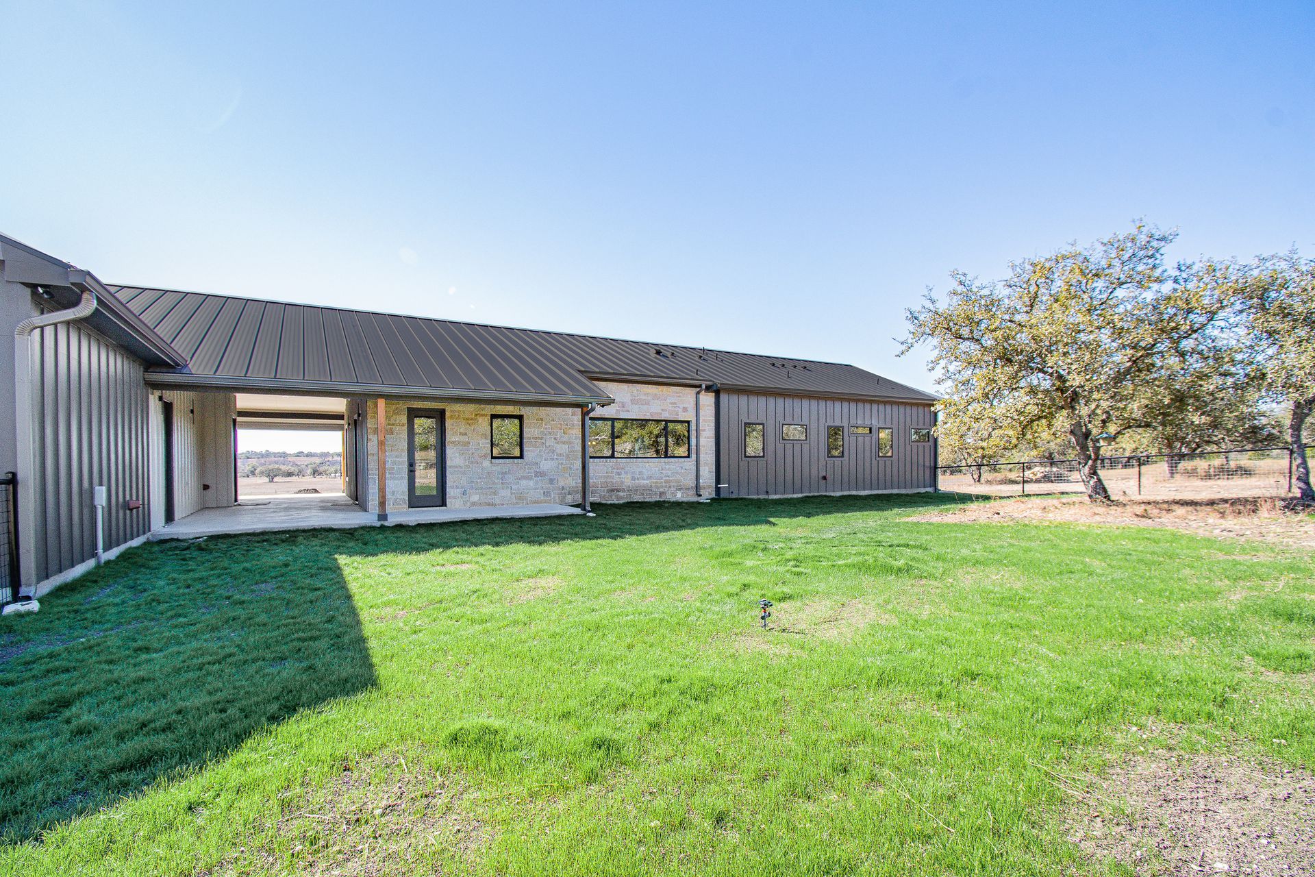 A large house is sitting on top of a lush green field.