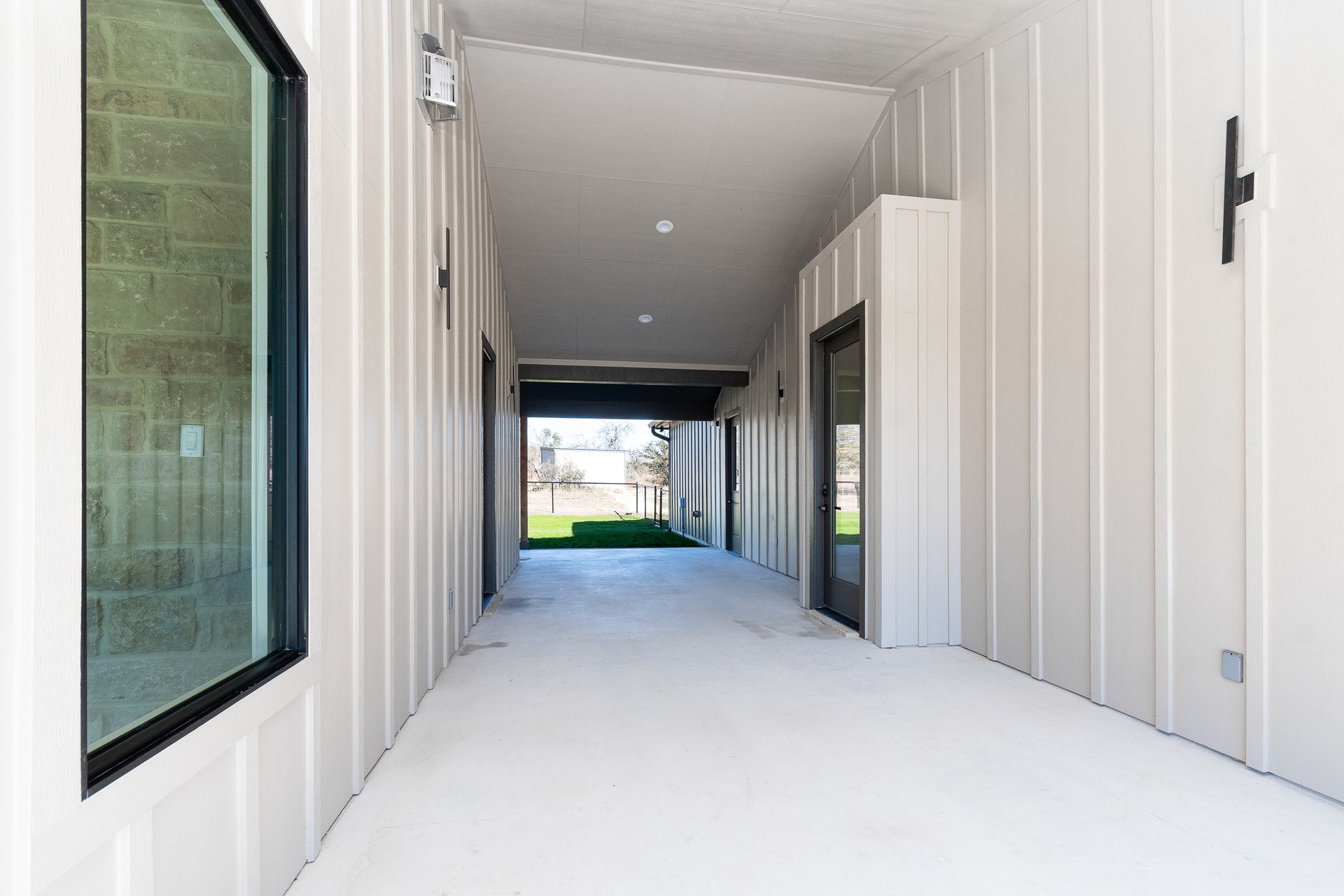 A long hallway leading to a garage in a house.
