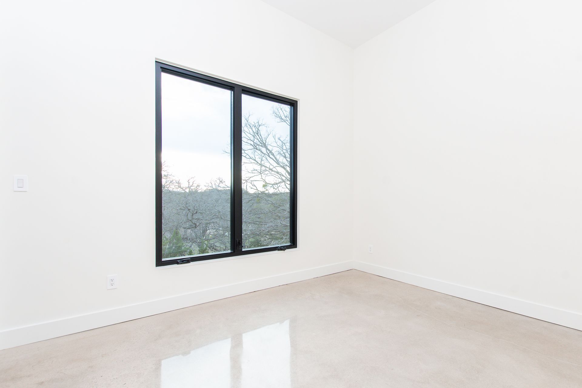 An empty room with two windows and a carpeted floor.