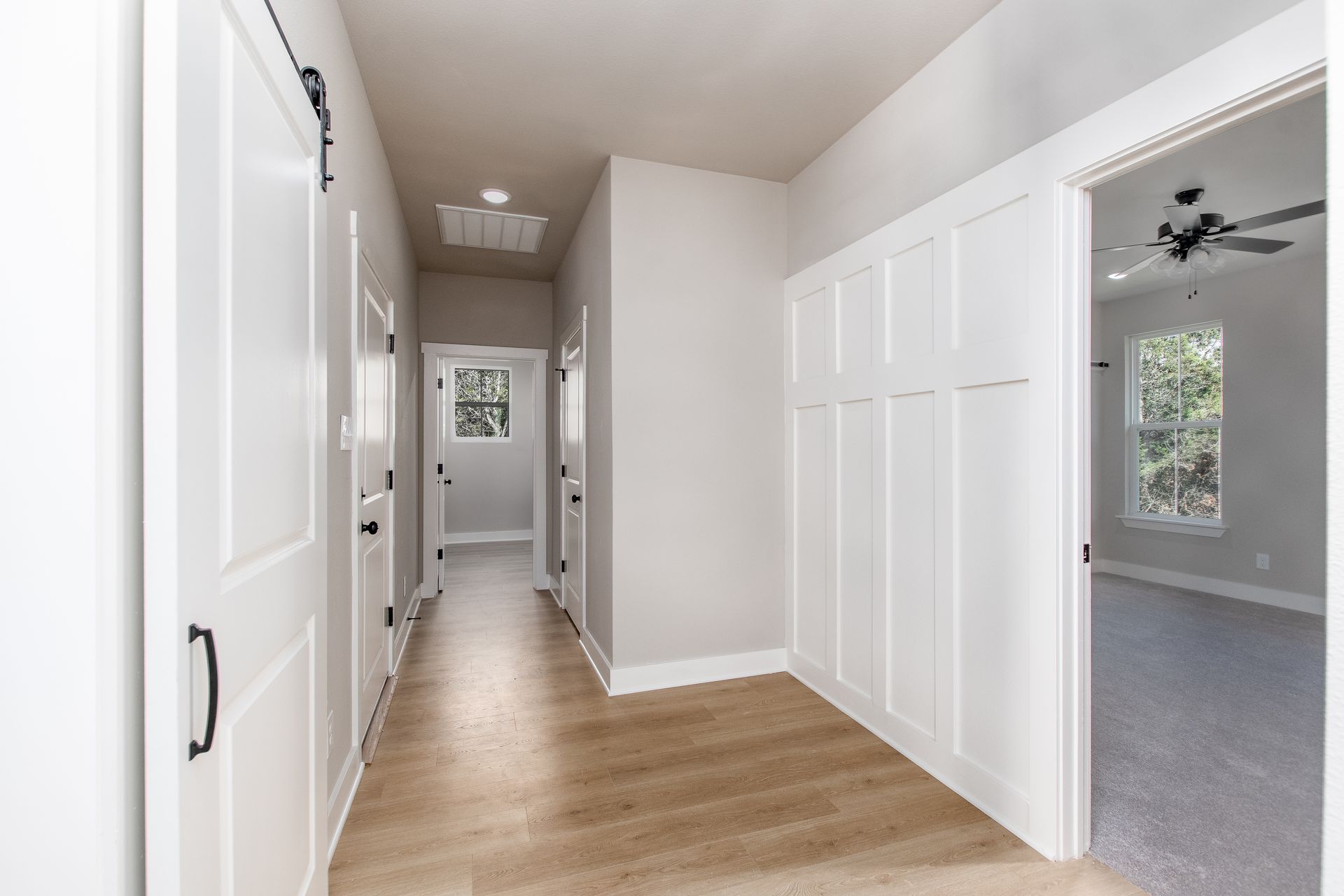 A hallway in a house with a ceiling fan