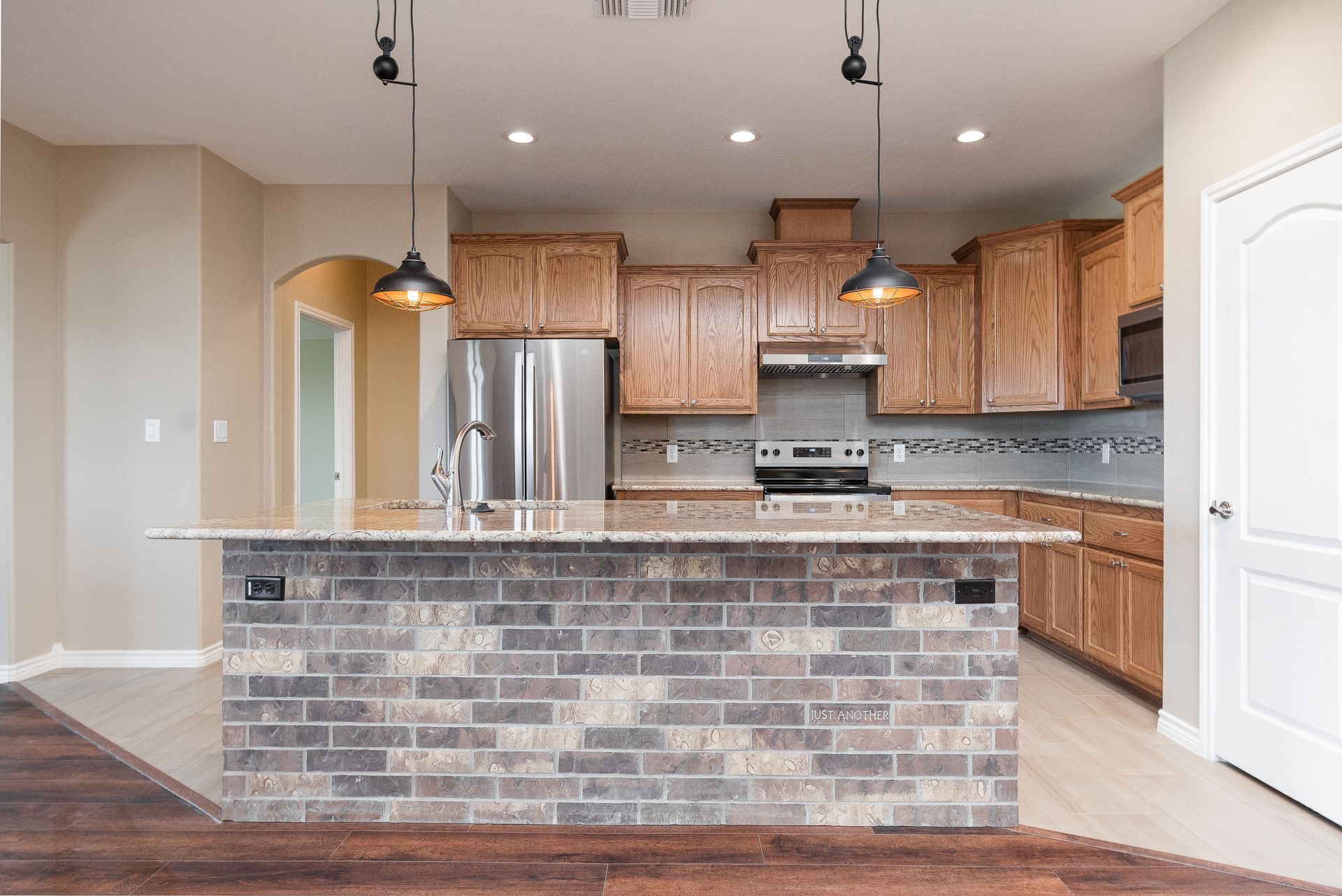 A kitchen with a brick island in the middle of it.