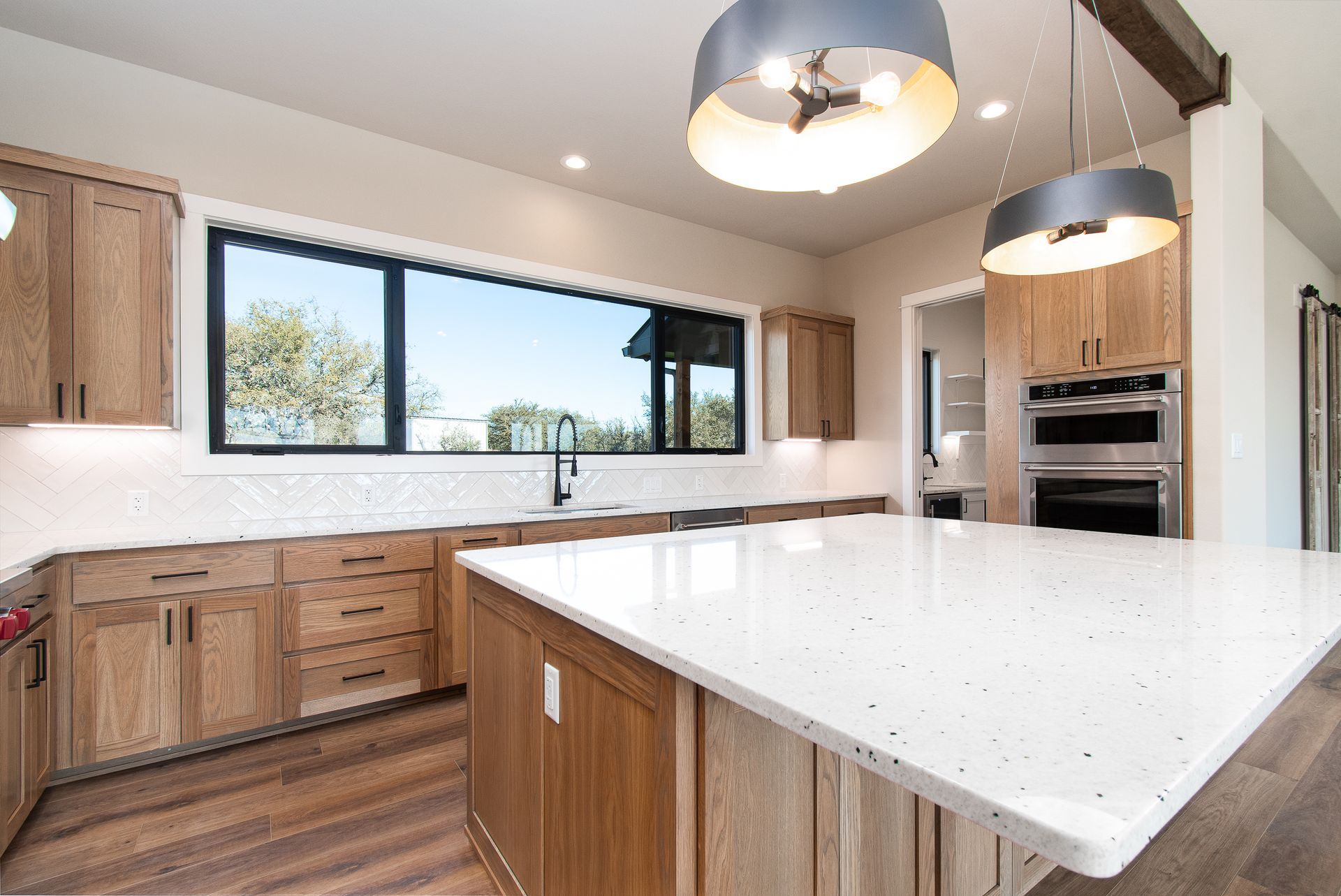 A kitchen with a large island and a large window.