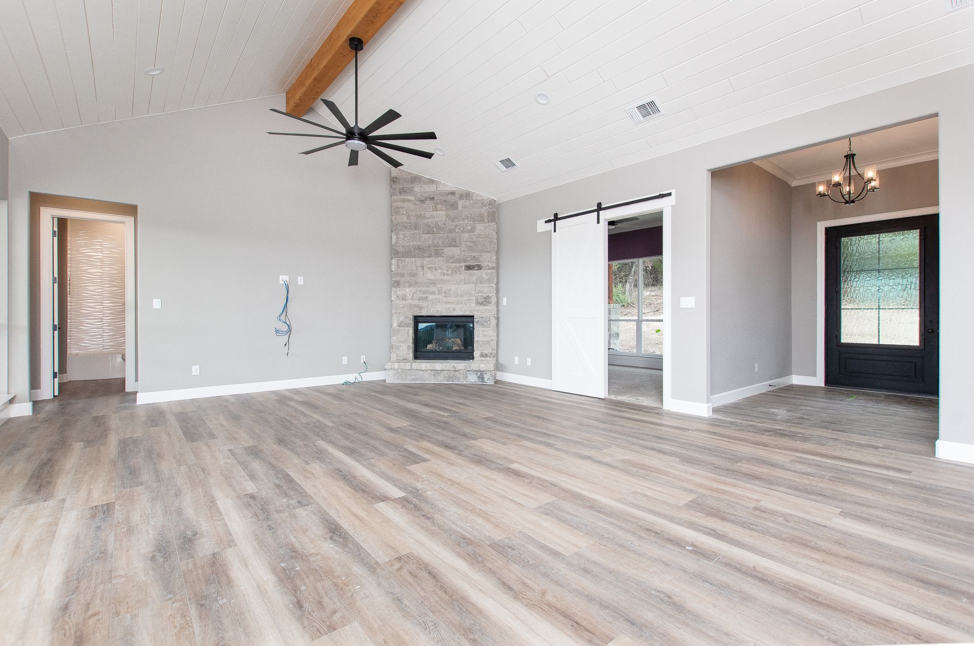An empty living room with hardwood floors and a fireplace.