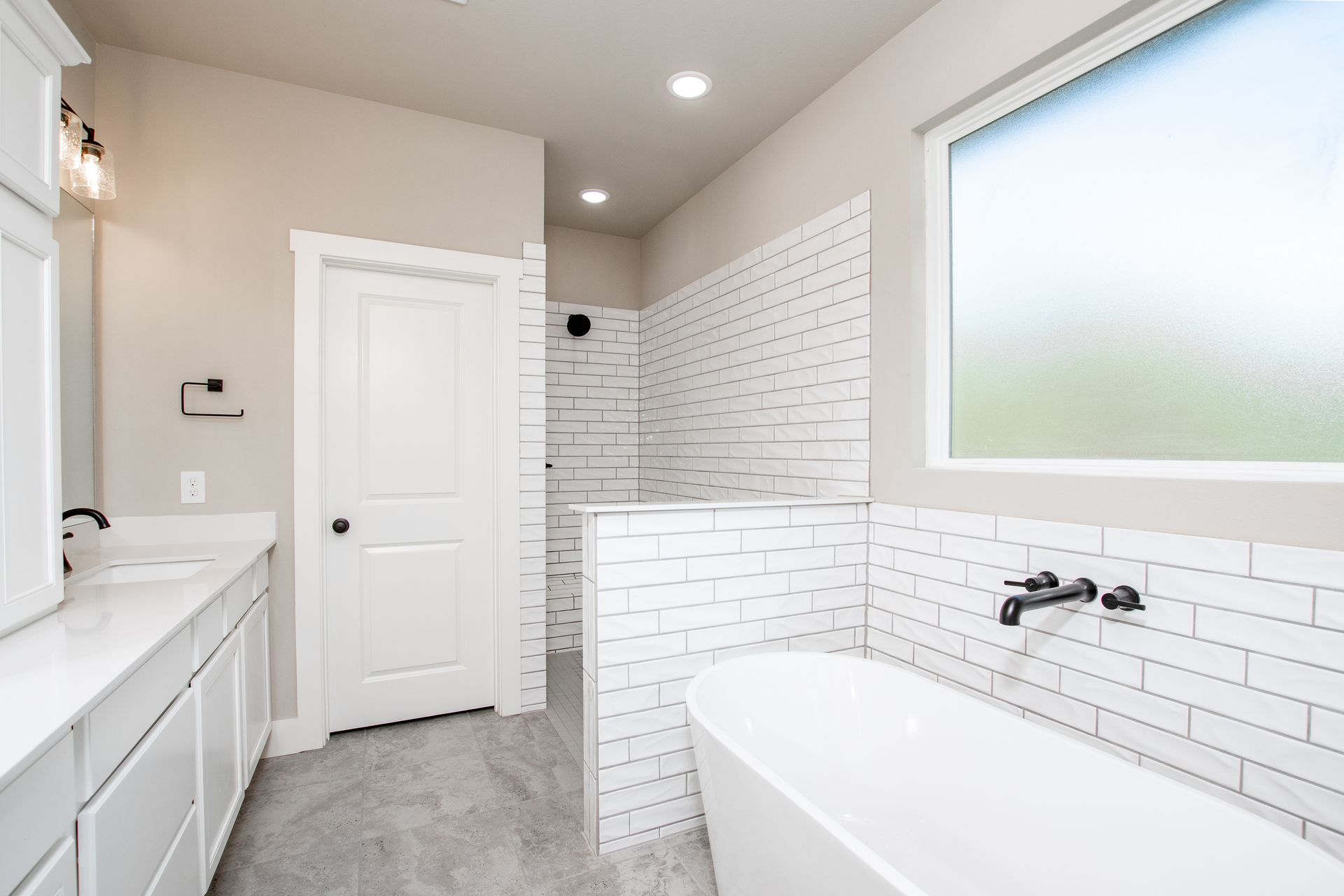 A bathroom with a tub , sink , and shower.