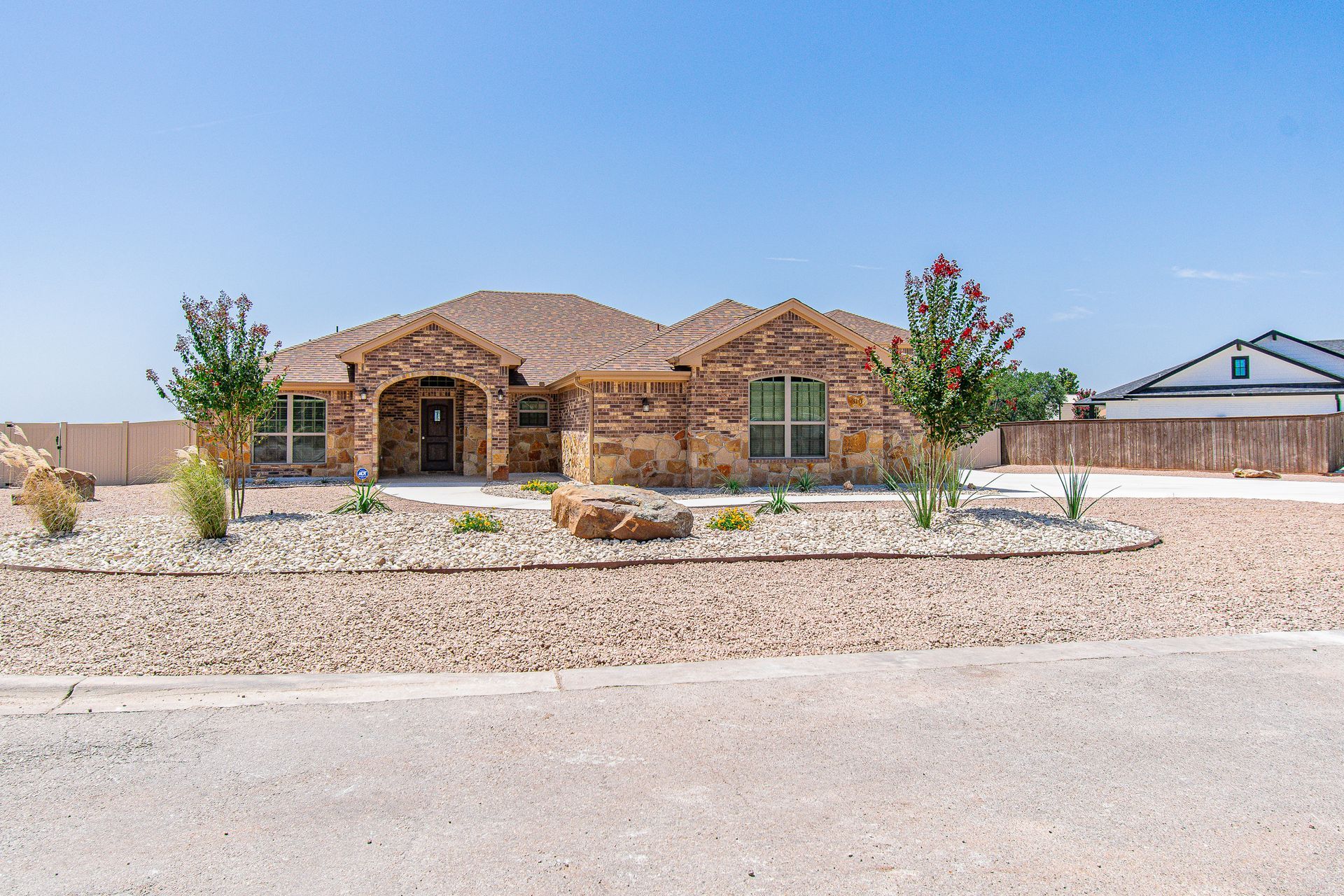 A large brick house is sitting on top of a dirt hill.