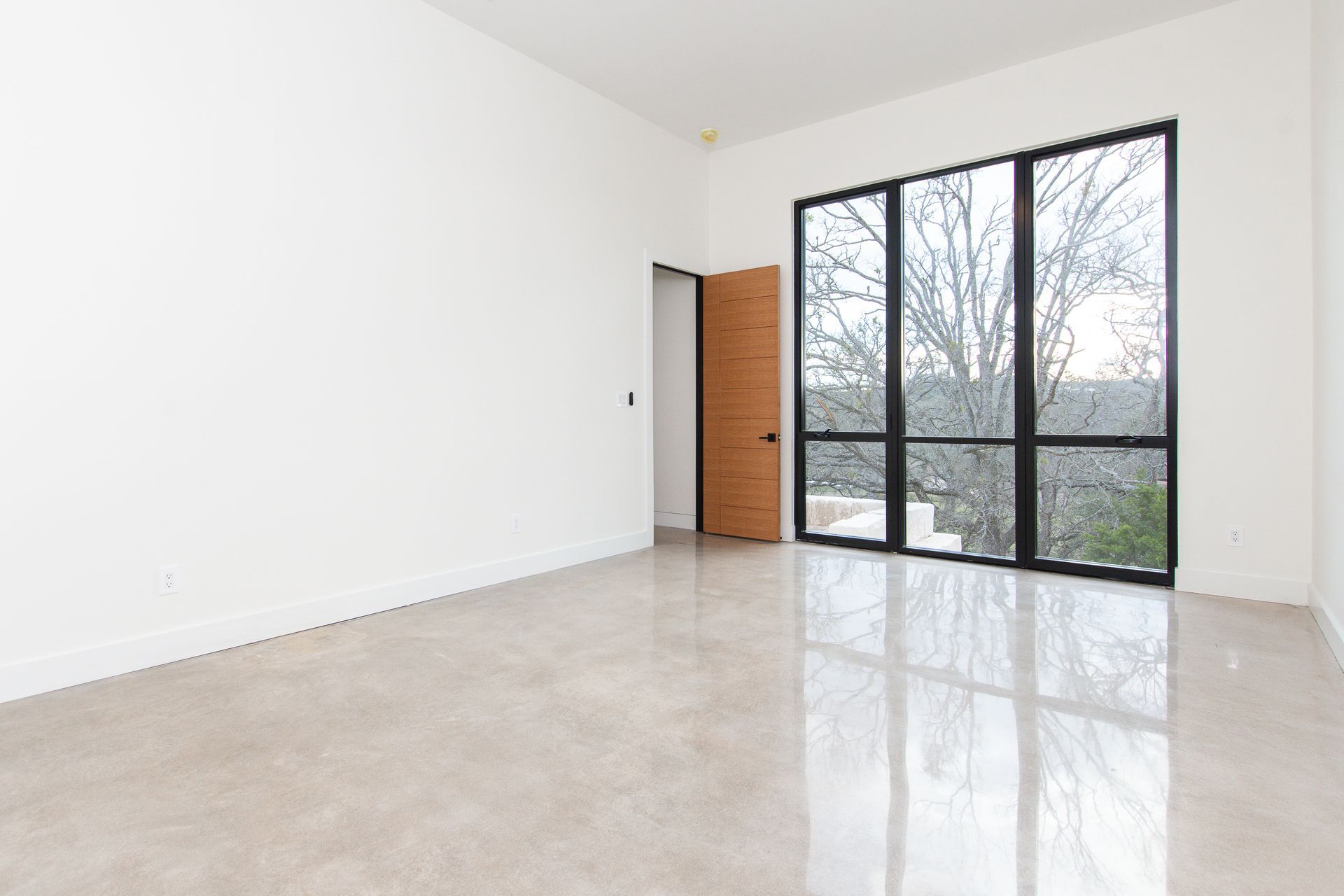 An empty room with a lot of windows and a door.