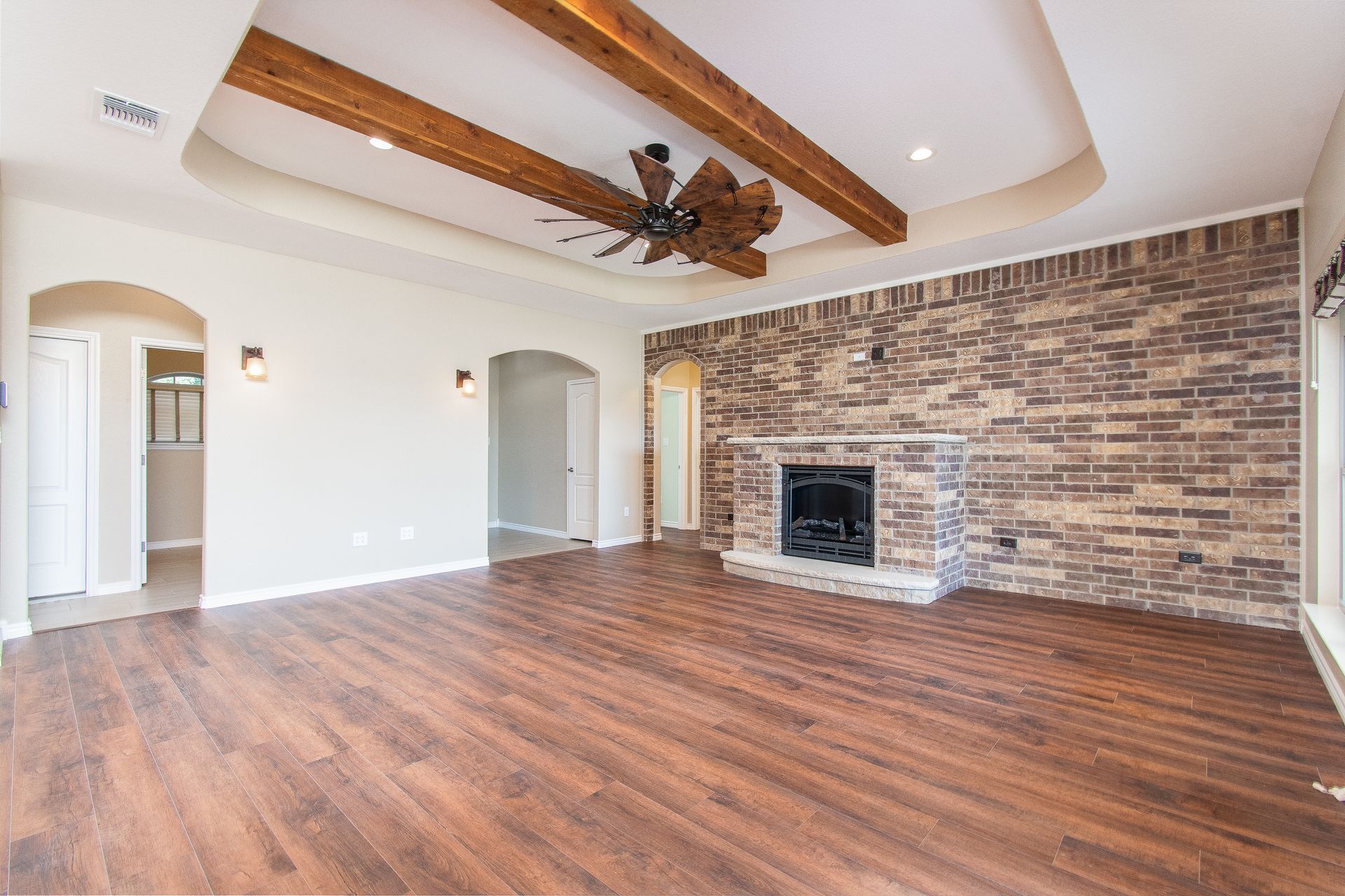 An empty living room with hardwood floors and a fireplace.